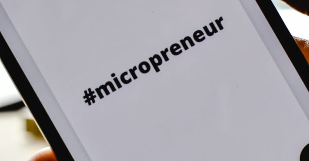Close-up of a hand holding a smartphone with the hashtag #micropreneur on screen, symbolizing entrepreneurship.